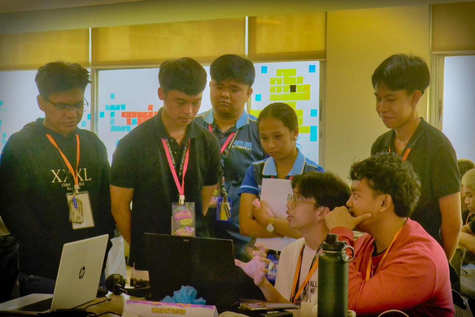 Team gathered around a laptop during a consultation at Create & Conquer 2026