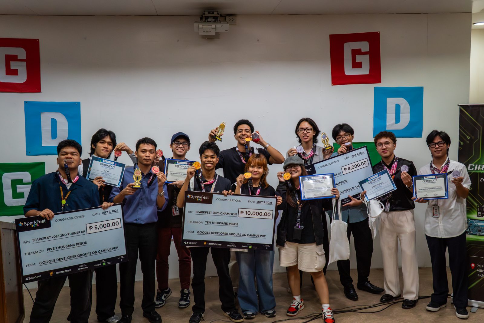 SparkFest 2026 winning teams holding their prize checks, medals and trophies